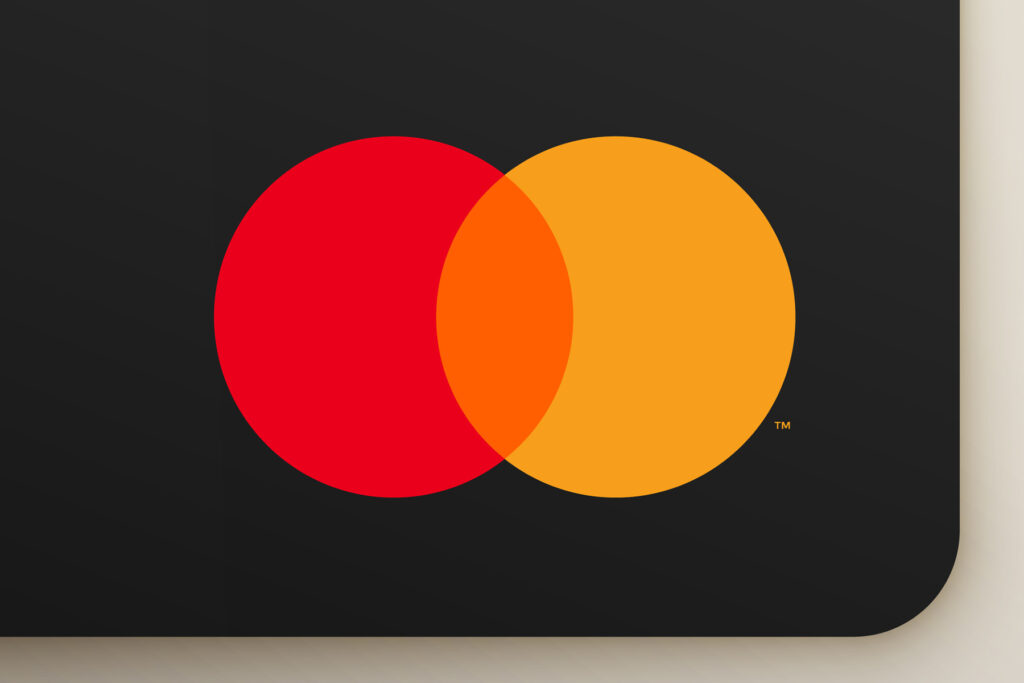 オレンジ色のロゴデザインの有名企業&ブランド事例20選［2024年最新版］という記事を説明するメイン画像。クレジットカードに印刷されたMastercardのロゴ