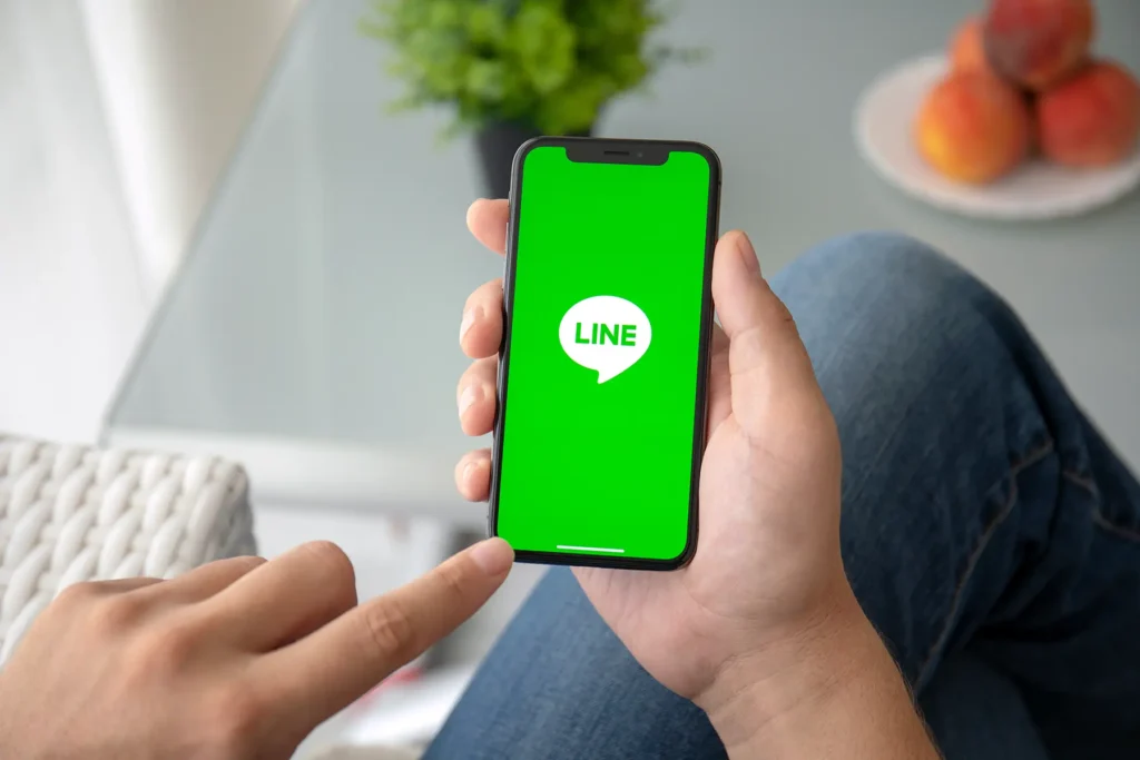 手に持ったスマートフォンでLINEを操作している